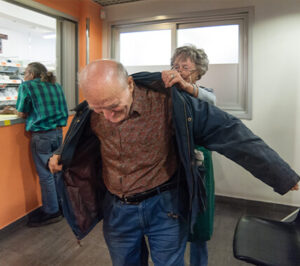 Operatore aiuta utente ad indossare giacca | OSF